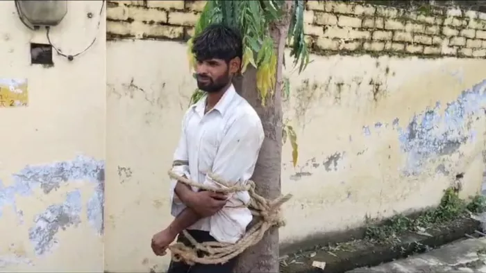 पेड़ से बंधा हुआ कर्मचारी। फोटो - सोशल मीडिया।