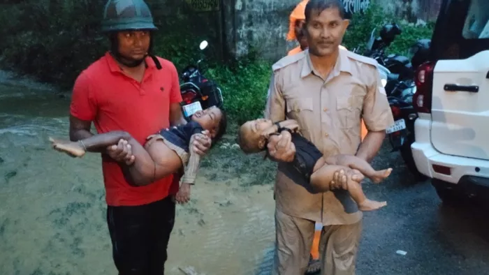 बच्चों को निकालकर अस्पताल ले जाते फायर मैन ओमकार नाथ राव वर्दी में व अन्य बचाव दल का जवान।