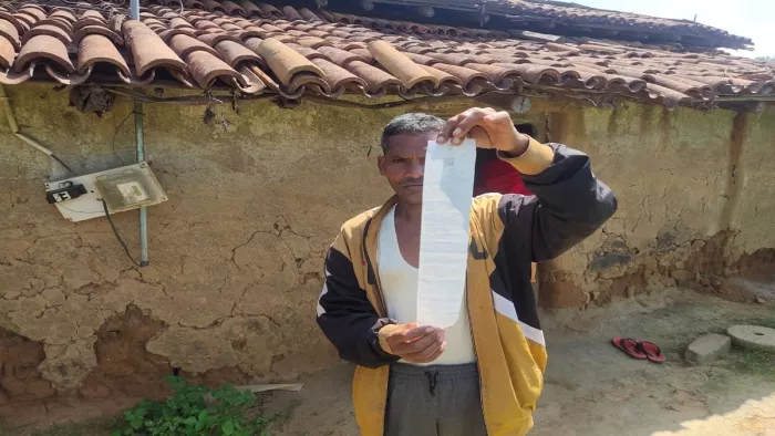 बिना कनेक्शन के 2400 का बिल दिखाता एक ग्रामीण।
