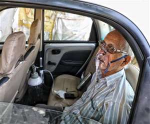 लखनऊ में रिपोर्ट के बिना भर्ती नहीं लिए जाने से अस्पताल के बाहर कार में ऑक्सीजन सिलिंडर लगा कर पड़े।