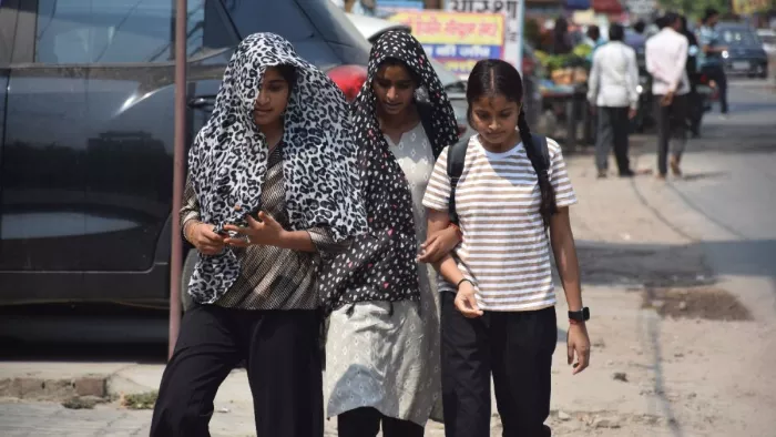 तेज धूप से बचने को दुपट्टा ओढ़े जातीं युवतियां। जागरण