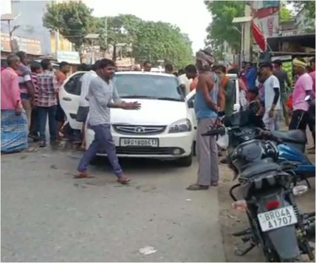 सारण के तरैया मेे कार से शराब की बोतल को लेकर भागते लोग। जागरण