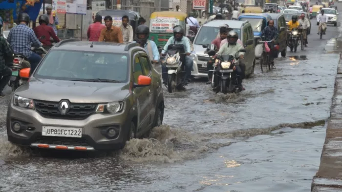 आगरा के गांधी नगर सर्विस रोड पर सोमवार सुबह वर्षा के दौरान हुए जलभराव में निकलते वाहन सवार।जागरण