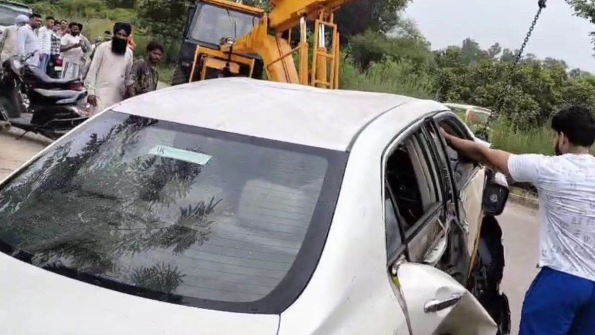 car fell into the canal while saving a bike rider driver came out after breaking the glass