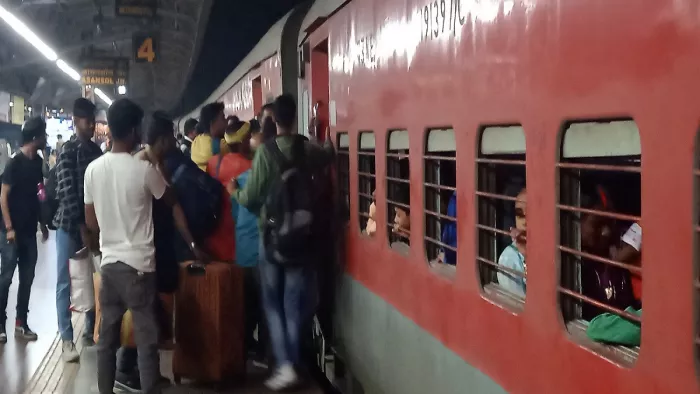 ट्रेन पर चढ़ने के लिए संघर्ष करते यात्री।
