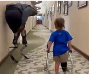 दिव्यांग व्यक्ति आर्टिफीसियल पैरों की मदद से दौड़कर बच्चे के पास आता है।