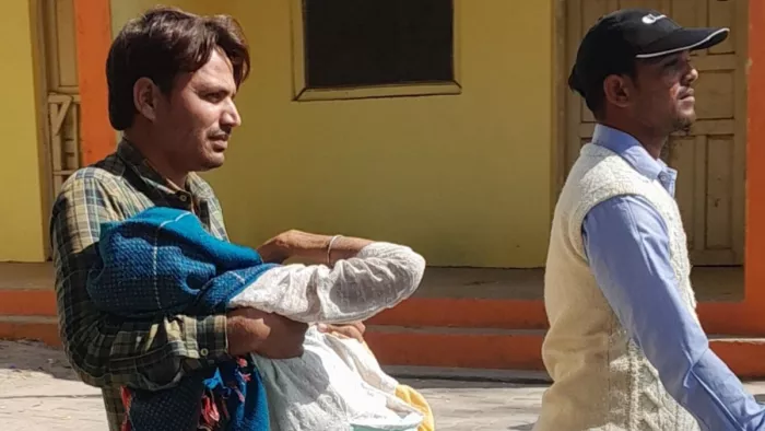 जिला अस्पताल में बुजुर्ग महिला को गोद में उठाकर ले जाता युवक।- जागरण