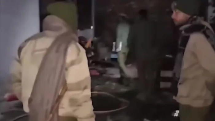 कठुआ के एक घर में लगी आग का जायजा लेते पुलिसकर्मी।