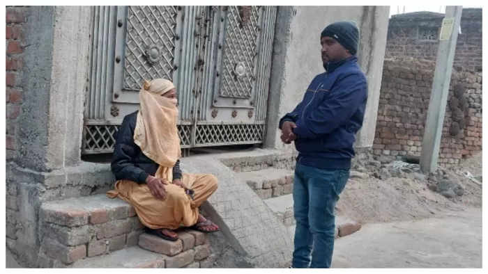धनबाद में प्रेमी के घर के बाहर बैठी युवती से मामले का जानकारी लेते मुखिया मनोज महतोl फोटो- जागरण