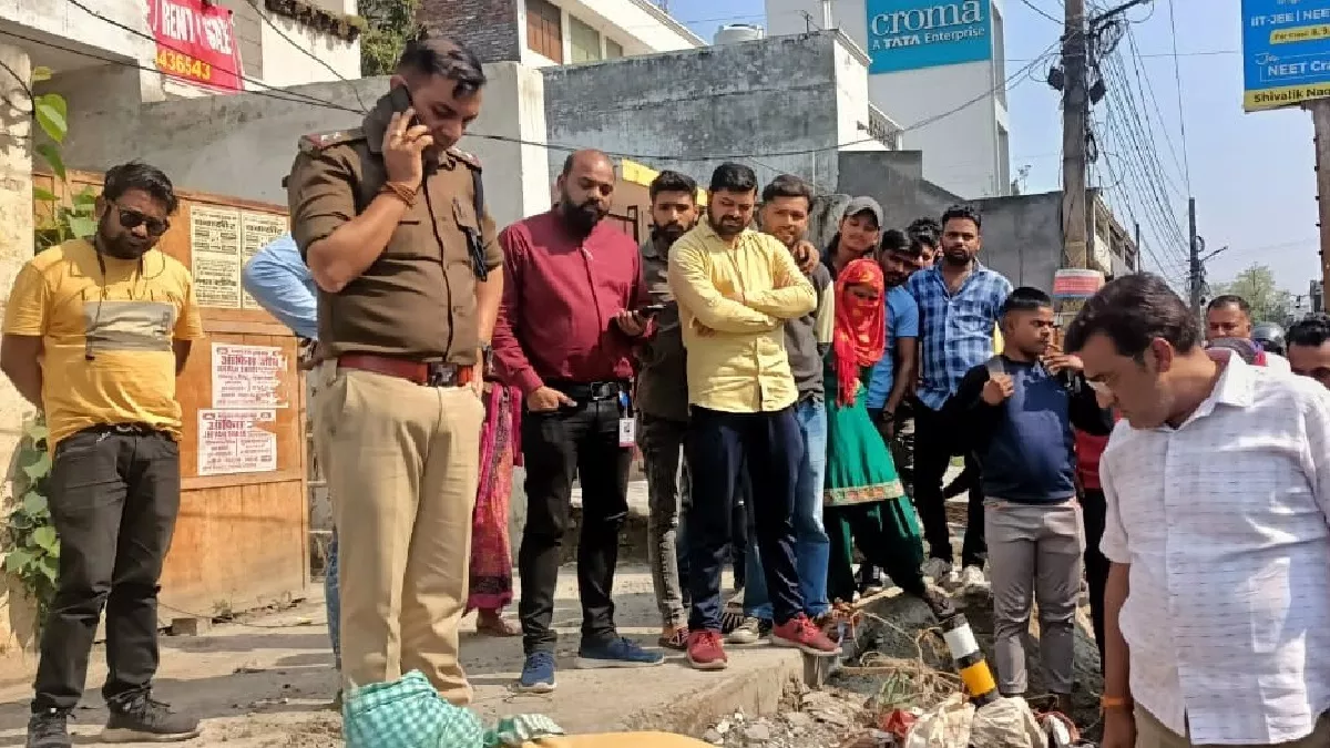 नाले से युवक का शव निकलवाती पुलिस और मौके पर जमा भीड़: जागरण