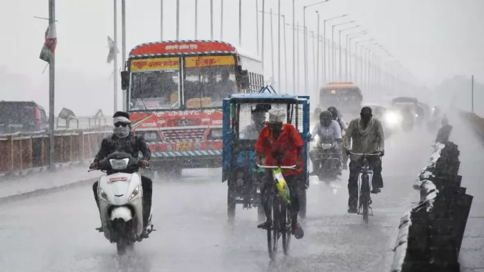 UP Weather Update: बारिश के बीच सड़कों पर गुजरते लोग। फाइल फोटो।