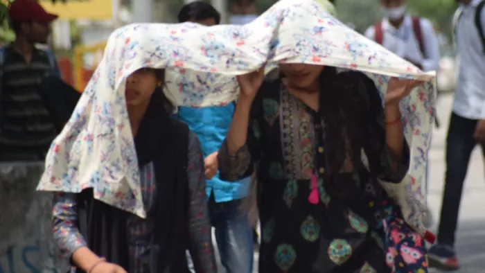 गर्मी में मुंह ढ़ककर जाती युवतियां। जागरण