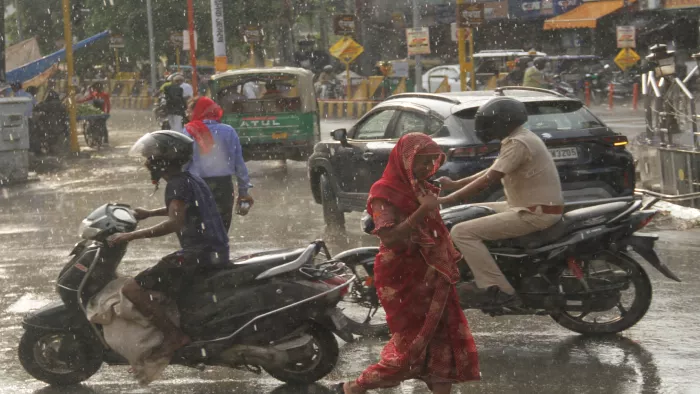वर्षा के दौरान भीगते हुए जाते लोग। जागरण