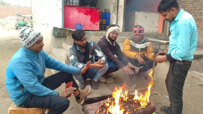 UP Weather Update: यूपी में मौसम अब साफ होने लगेगा। ठंड से बचने के लिए अलाव तापते लोग।