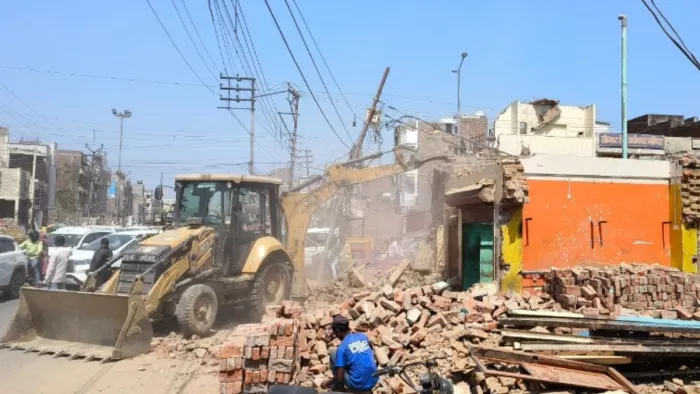 मंडुवाडीह चौराहे के पास ध्वस्तीकरण करते जेसीबी