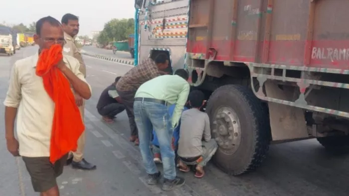 ट्रक में फंसी बाइक निकालने के प्रयास करते पुलिस व ग्रामीण। जागरण