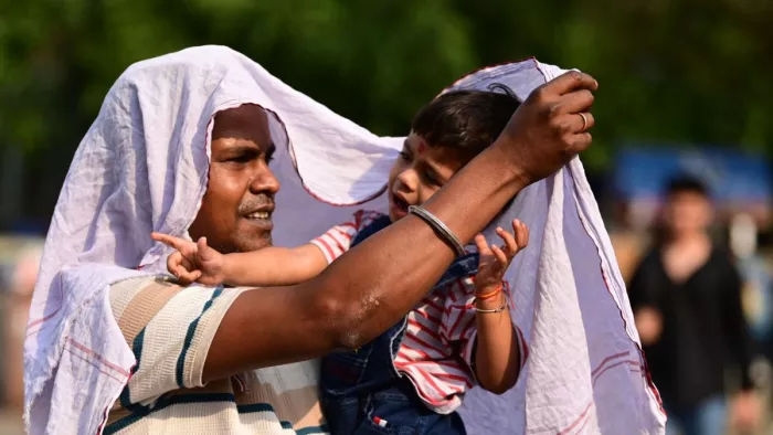 तेज धूप और गर्मी से बचाव के लिए युवक ने गमछे से ढका सिर। फाइल फोटो