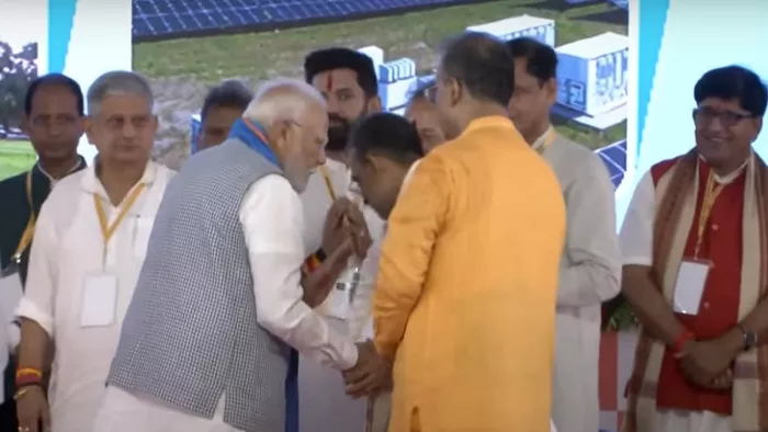 उपेंद्र कुशवाहा के कान में कुछ कहते प्रधानमंत्री नरेंद्र मोदी और सामने खड़े चिराग पासवान।