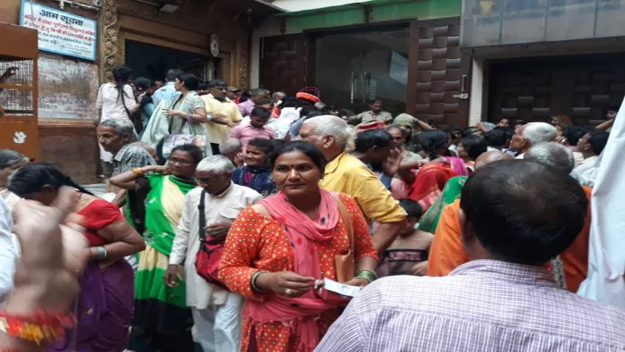 Banke Bihari Vrindavan: देर रात हुए हादसे के बाद शनिवार सुबह बांकेबिहारी मंदिर में दर्शन करने जाते लोग।