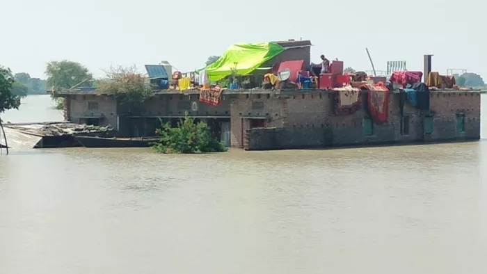 बलिया: बैरिया क्षेत्र के चांददीयर में एनएच कटने के बाद बाढ़ के पानी से घिरे मकान।