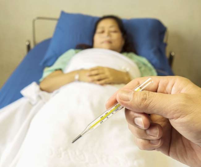 बीमार महिला का टेंपरेचर कर देखता डॉक्टर