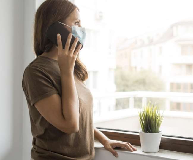 क्वारंटीन के दौरान फोन पर बात करती महिला