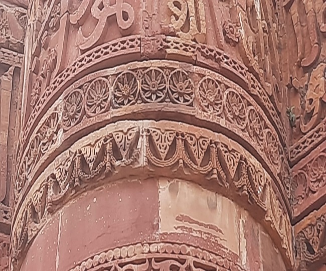 कुतुबमीनार की दीवार पर स्पष्ट रूप से दिखती कमल, वंदनवार व लटकती घंटी की आकृति। ये चिह्न हिंदू संस्कृति के प्रतीक हैं।