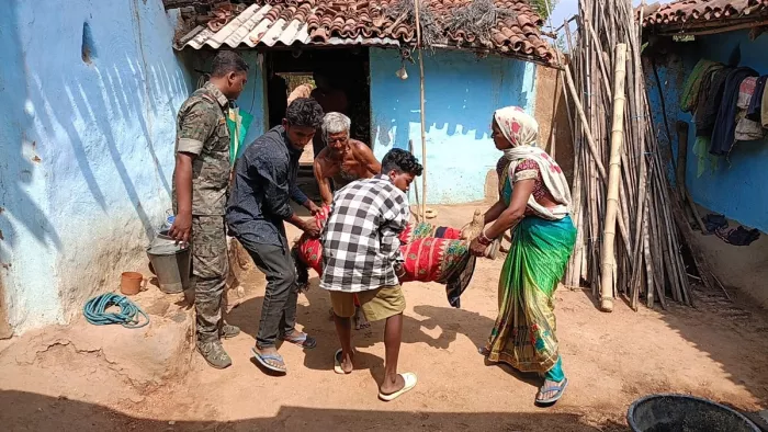 शव को कमरे से निकालकर बाहर ले आते परिजन