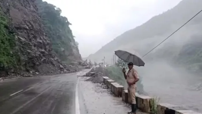 मंडी कुल्लू हाईवे पर हो रहा भूस्खलन व वाहन सवारों को रोकने के लिए तैनात पुलिस कर्मचारी।