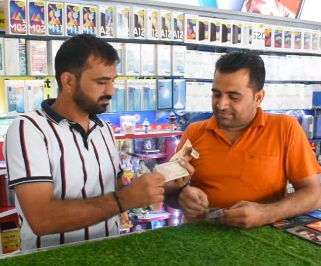 सिरसा में अपनी मोबाइल शाप में करेंसी की कलेक्शन दिखाते अजय।