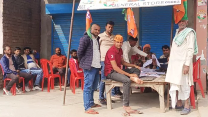 गांव रठेरा में लगे भाजपा के बस्ता पर वोटर लिस्ट देखते मतदाता। जागरण