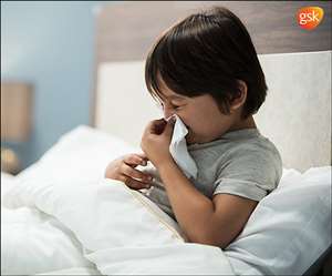 छींकते हुए नाक पर रूमाल रखता बच्चा