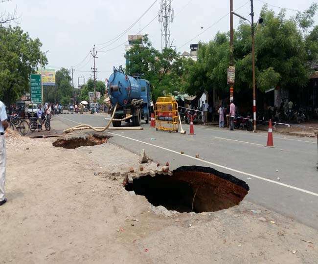 बारिश में मिट्टी धंसने से आगरा की सड़क पर गड्ढा।