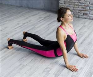 घर के अंदर कोबरा पोज़ करती युवती