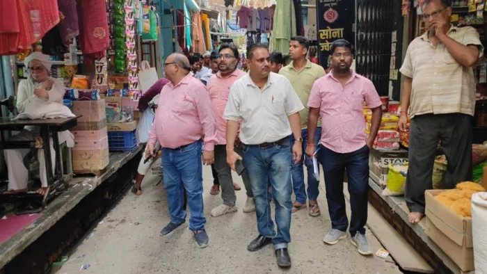 आजमगढ़: फूलपुर बाजार में चेकिंग करते बिजली विभाग के अधिकारी। जागरण