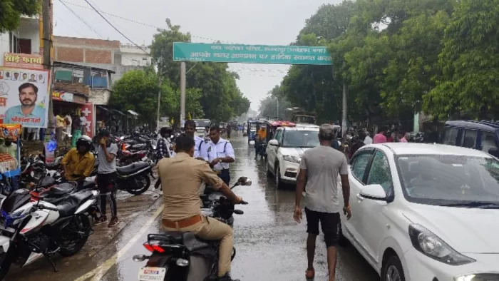 अकबरपुर के पटेल नगर में बुधवार की दोपहर बारिश के दौरान आवागमन करते राहगीर-जागरण
