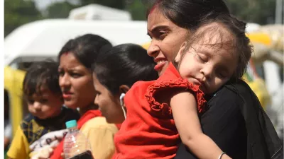 राजधानी पटना में तेज धूप के बीच मां की गोद में सोया बच्‍चा। जागरण