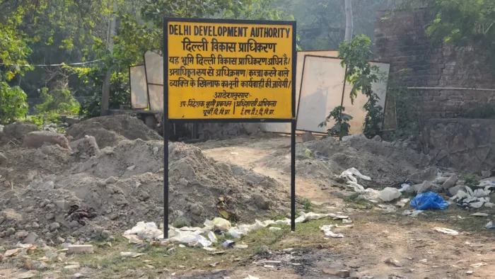 जमीन पर लगा डीडीए का बोर्ड। जागरण