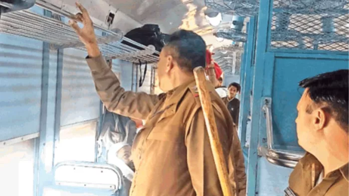 ट्रेन में यात्रियों के सामान की जांच करते जीआरपी कर्मी।