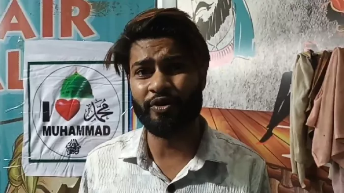 बागपत में दुकान पर लगाए गए पोस्टर के बारे में जानकारी देता शाकिब। जागरण