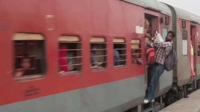 यात्री जान जोखिम में डालकर ट्रेन के द्वार पर झूलकर या लटककर यात्रा करने को विवश