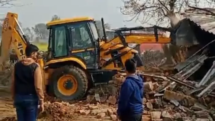 Noida News: खंडेरा गांव में मकान तोड़ता बुलडोजर। फोटो सौ. सुधी पाठक।