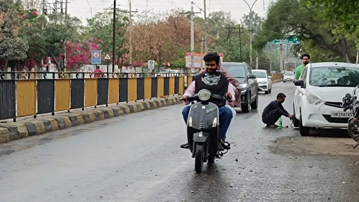 हल्की बूंदाबांदी के बीच रोड से गुजरते वाहन चालक । जागरण