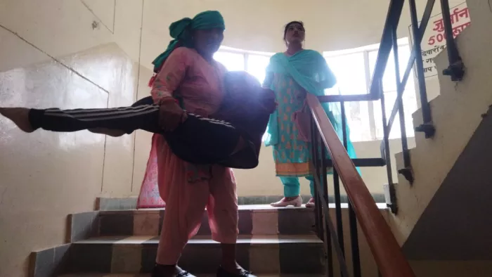 दिव्यांग पति को गोद में उठाकर पेशी के लिए पहुंची महिला।