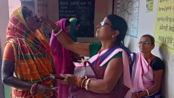 सारण जिले के एक बूथ पर लू से बचाव की दवा पिलाती स्वास्थ्यकर्मी।