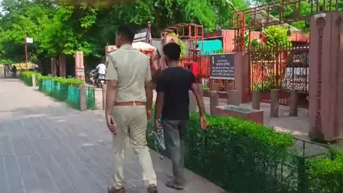 Agra News: हथकड़ी में कैदी को ताजमहल के रास्ते पर लेकर जाता पुलिसकर्मी। वीडियो से ली गई तस्वीर।