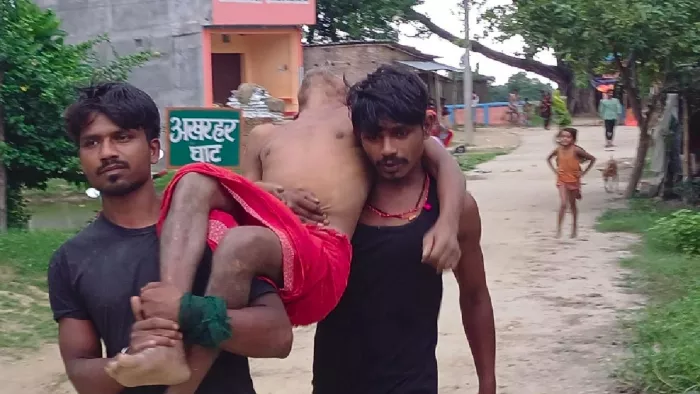 कंंधे पर पिता का शव लेकर आते पुत्र।