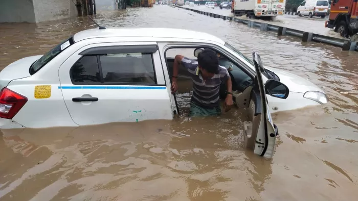 दिल्ली-गुरुग्राम एक्सप्रसवे पर नरसिंहपुर गांव के पास जलभराव में फंसी कार। फोटो- संजय गुलाटी