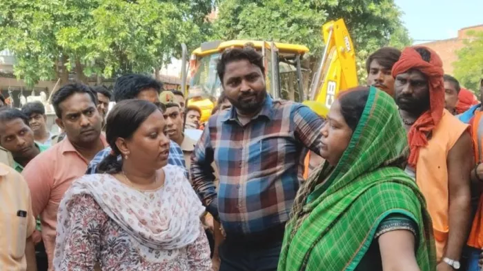 अवैध निर्माण के ध्वस्तीकरण की कार्रवाई करती टीम