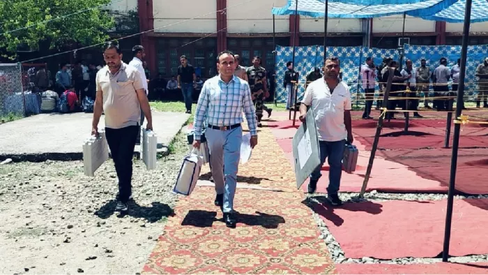 Jammu News: आरएस पुरा से ईवीएम मशीनों लेकर चुनावी स्थल की ओर जाते कर्मचारी।